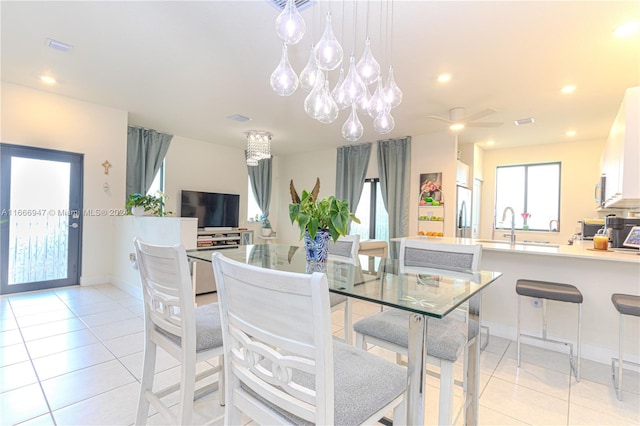 tiled dining space with sink and a notable chandelier