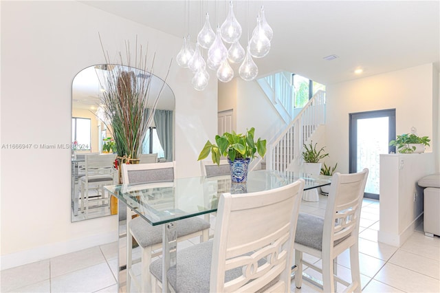 tiled dining space featuring an inviting chandelier