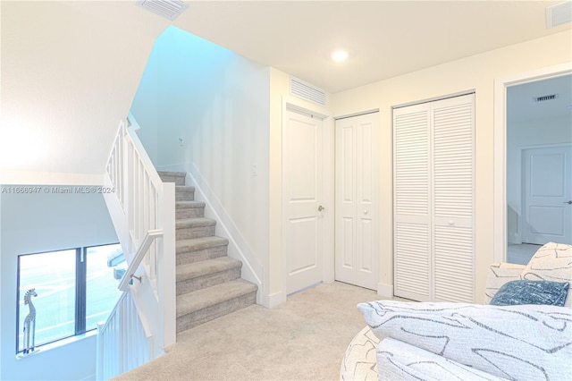 bedroom with light carpet and two closets