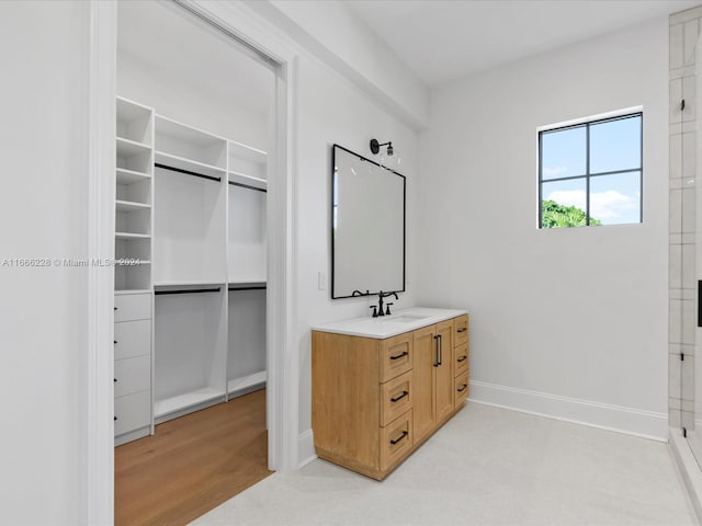 interior space with wood-type flooring, vanity, and walk in shower