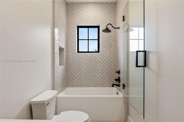 bathroom with toilet and tiled shower / bath combo