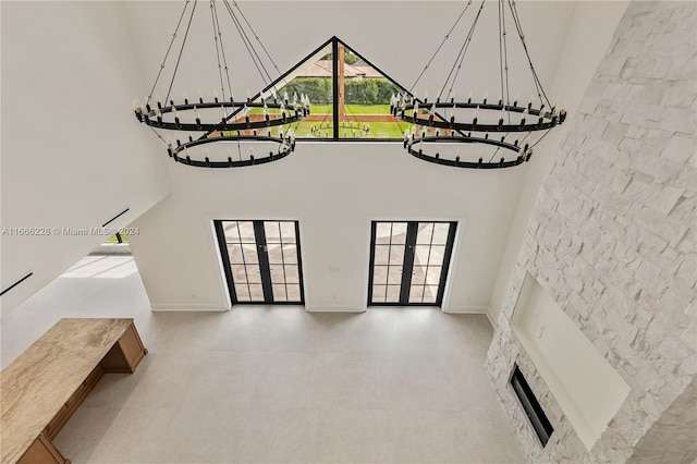 unfurnished living room with french doors, plenty of natural light, and a high ceiling