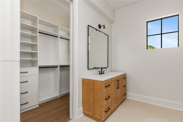 walk in closet with light hardwood / wood-style flooring and sink