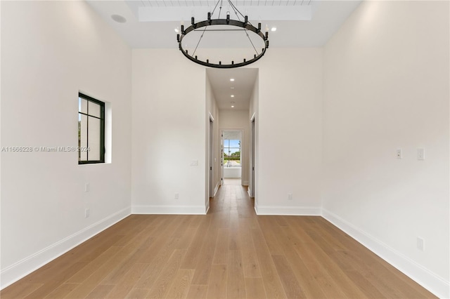 hall with light hardwood / wood-style floors and an inviting chandelier