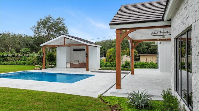 view of swimming pool with a patio, a lawn, and an outdoor structure