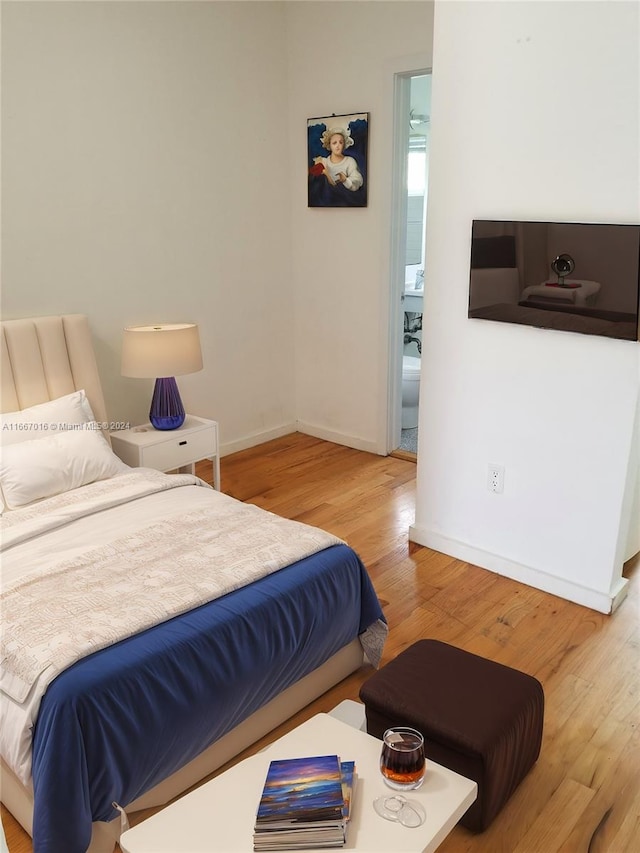 bedroom featuring ensuite bathroom and hardwood / wood-style flooring