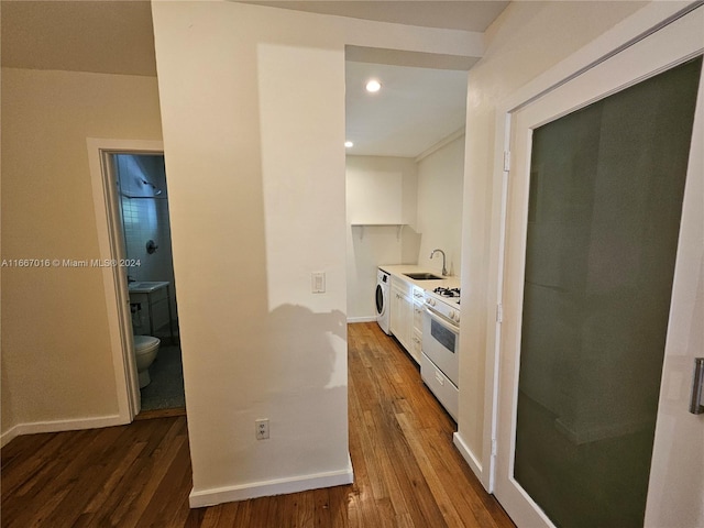 kitchen featuring wood-type flooring, sink, white range with gas cooktop, and white cabinetry