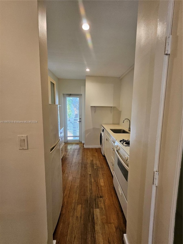 kitchen featuring washer / clothes dryer, white cabinets, gas range gas stove, dark hardwood / wood-style flooring, and sink