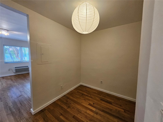 empty room featuring a wall mounted air conditioner and dark hardwood / wood-style flooring