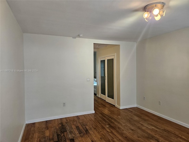 unfurnished room with dark hardwood / wood-style flooring