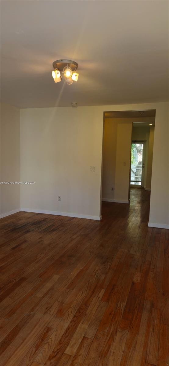 empty room with dark hardwood / wood-style flooring