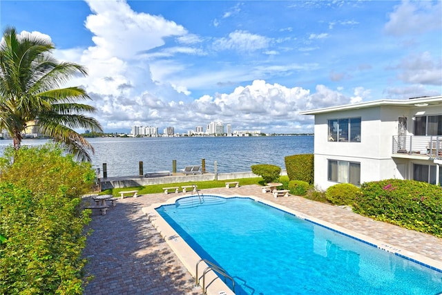 view of swimming pool with a patio and a water view