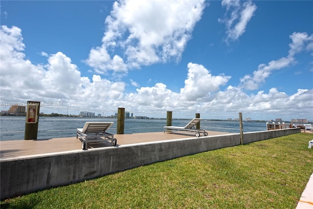 view of dock featuring a water view and a yard