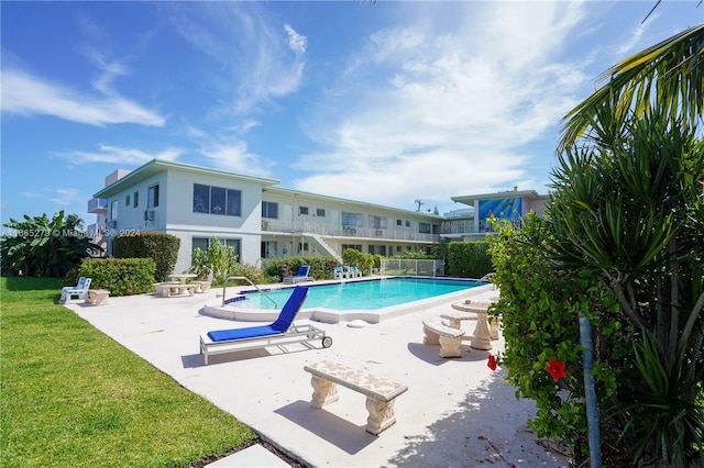 view of swimming pool with a patio area and a yard