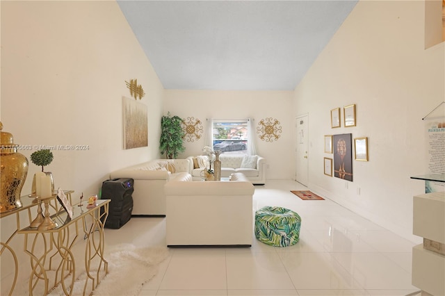 living room featuring high vaulted ceiling and light tile patterned flooring