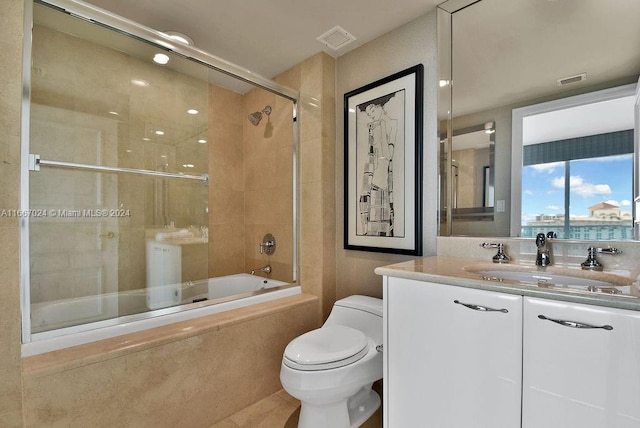 full bathroom with enclosed tub / shower combo, toilet, vanity, and visible vents