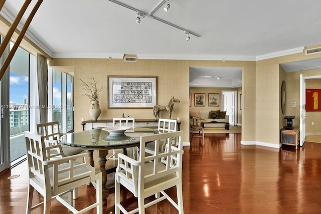dining room featuring wood finished floors, visible vents, track lighting, and ornamental molding