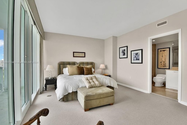 bedroom featuring ensuite bath, carpet floors, visible vents, and baseboards