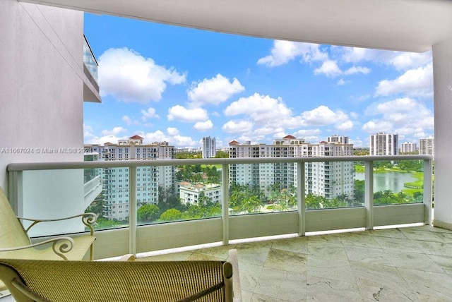 balcony with a water view and a view of city