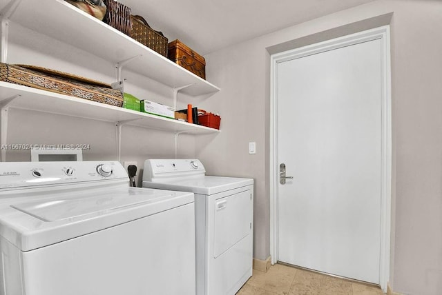 laundry area featuring baseboards, separate washer and dryer, and laundry area