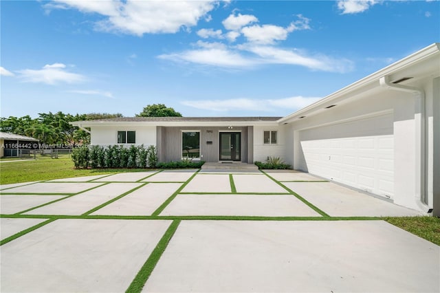 single story home featuring a garage, driveway, and stucco siding