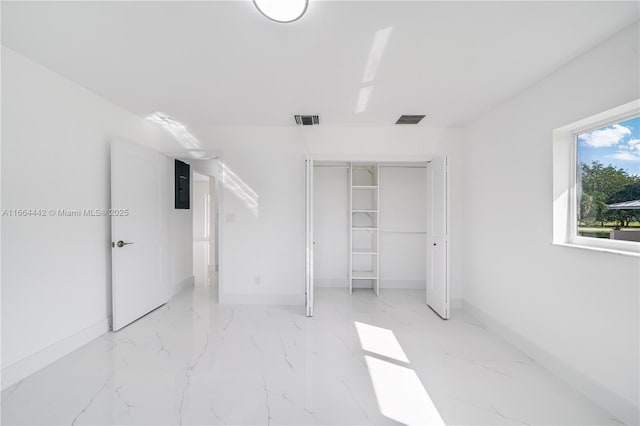 unfurnished bedroom with a closet, visible vents, marble finish floor, and baseboards