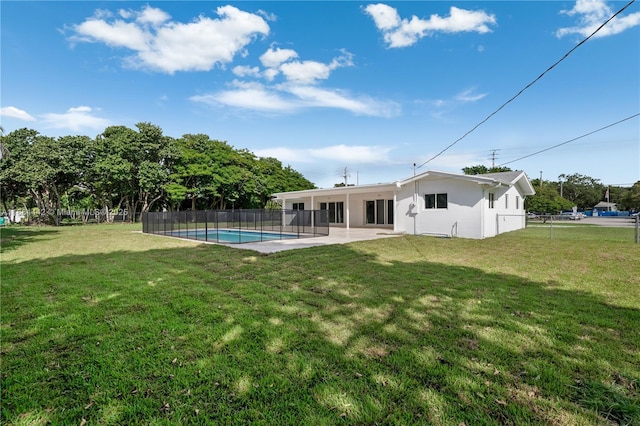 back of property featuring a lawn, a fenced in pool, a patio, fence, and stucco siding