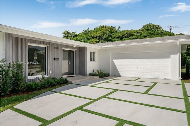 ranch-style home with concrete driveway, an attached garage, and stucco siding