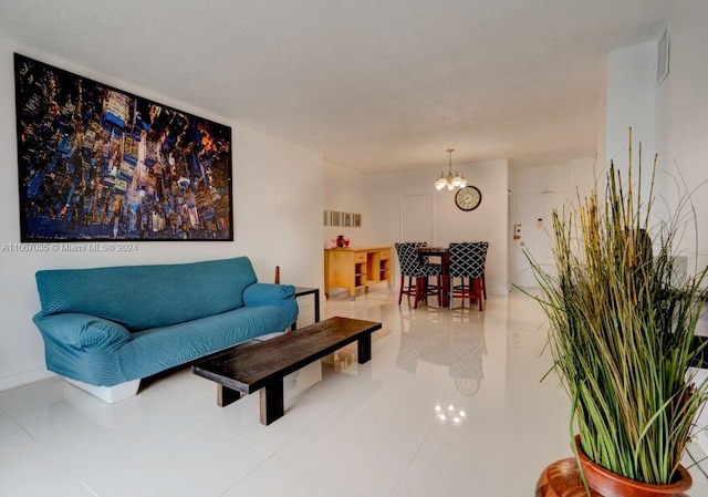 tiled living room featuring a notable chandelier and a textured ceiling