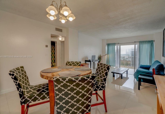 dining space featuring light tile patterned flooring, a textured ceiling, and a notable chandelier