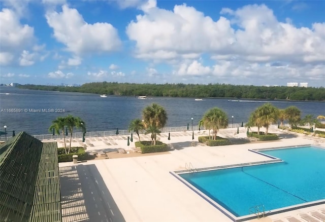 view of swimming pool with a water view and a patio area