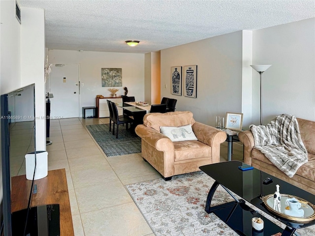 tiled living room featuring a textured ceiling