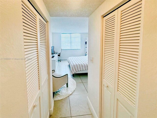 500 Bayview Dr Unit 325, Sunny Isles Beach, FL 33160 - hallway with tile patterned flooring and a textured ceiling