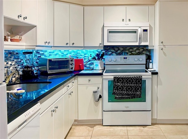 500 Bayview Dr Unit 325, Sunny Isles Beach, FL 33160 - kitchen with white appliances, dark countertops, backsplash, and white cabinets