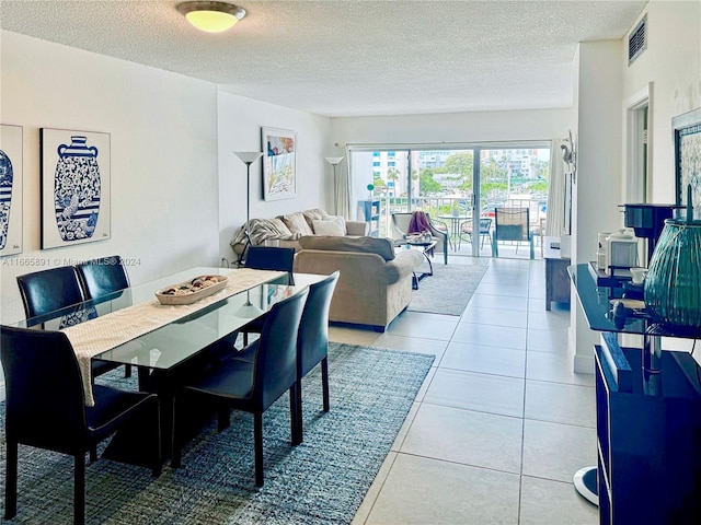 tiled dining area featuring a textured ceiling