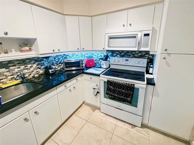 500 Bayview Dr Unit 325, Sunny Isles Beach, FL 33160 - kitchen with white appliances, a sink, decorative backsplash, and white cabinets