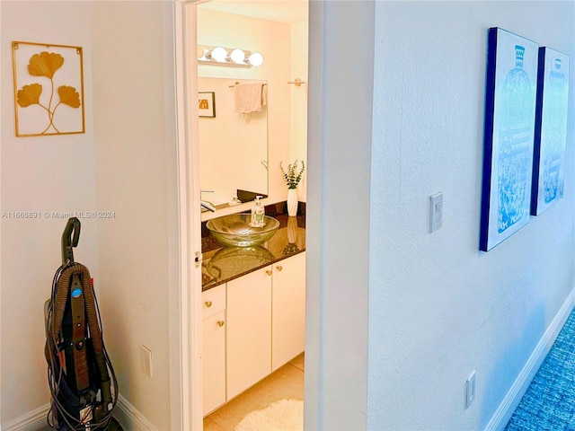 hall featuring light tile patterned floors and sink