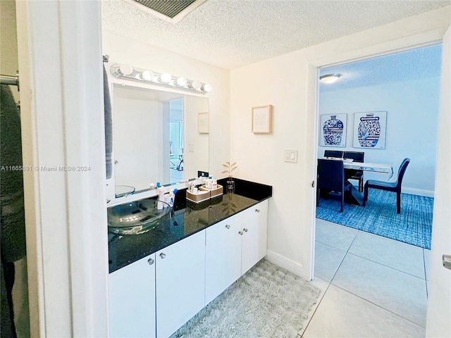 500 Bayview Dr Unit 325, Sunny Isles Beach, FL 33160 - bathroom featuring a textured ceiling, baseboards, tile patterned flooring, and double vanity