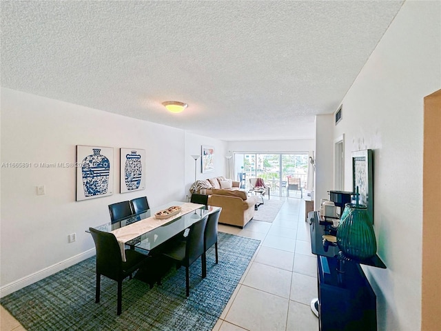 tiled dining space featuring a textured ceiling