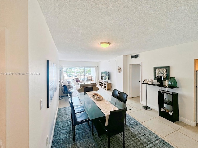 dining room with a textured ceiling and light tile patterned floors