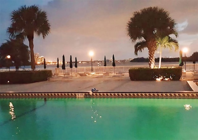 500 Bayview Dr Unit 325, Sunny Isles Beach, FL 33160 - pool at dusk featuring fence, an outdoor pool, and a water view
