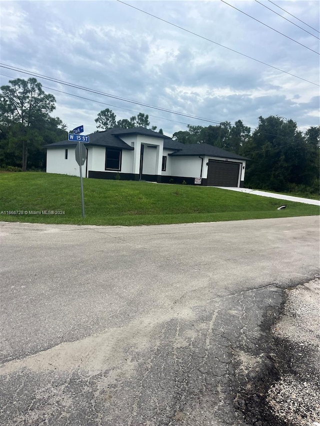 single story home featuring a front yard and a garage