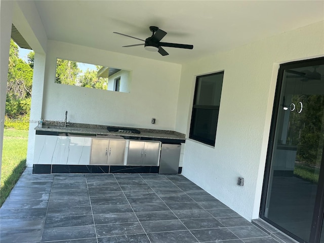 view of patio featuring ceiling fan, sink, and an outdoor kitchen