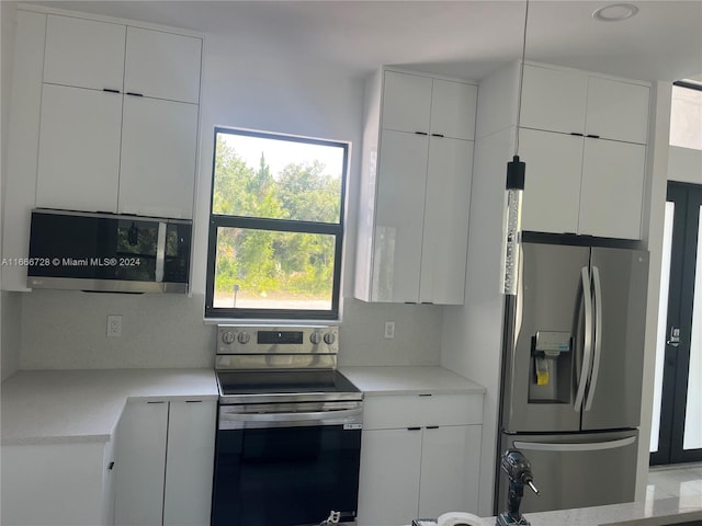 kitchen with decorative backsplash, light stone counters, stainless steel appliances, sink, and white cabinets