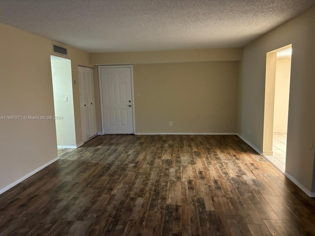 unfurnished room featuring a textured ceiling and dark wood-type flooring