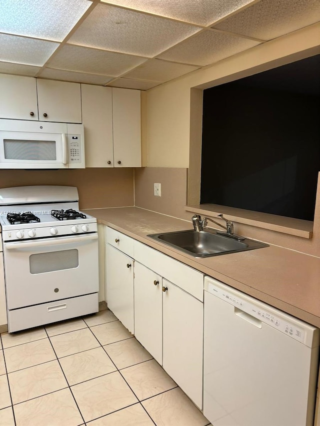 kitchen with white cabinetry, white appliances, light tile patterned floors, a paneled ceiling, and sink