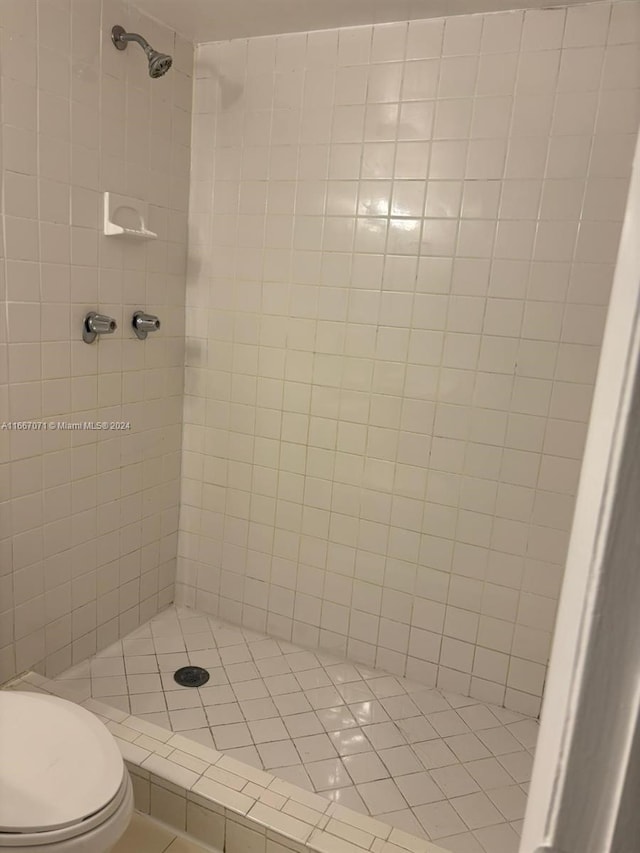 bathroom with tiled shower and toilet