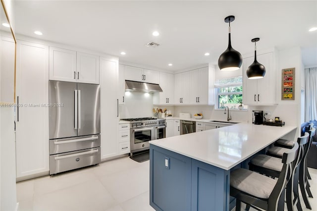 kitchen with white cabinets, kitchen peninsula, stainless steel appliances, decorative light fixtures, and sink