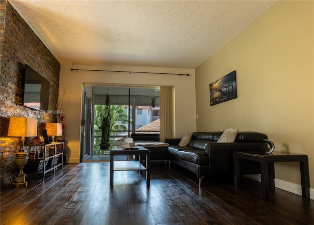 living room with a textured ceiling and dark hardwood / wood-style flooring