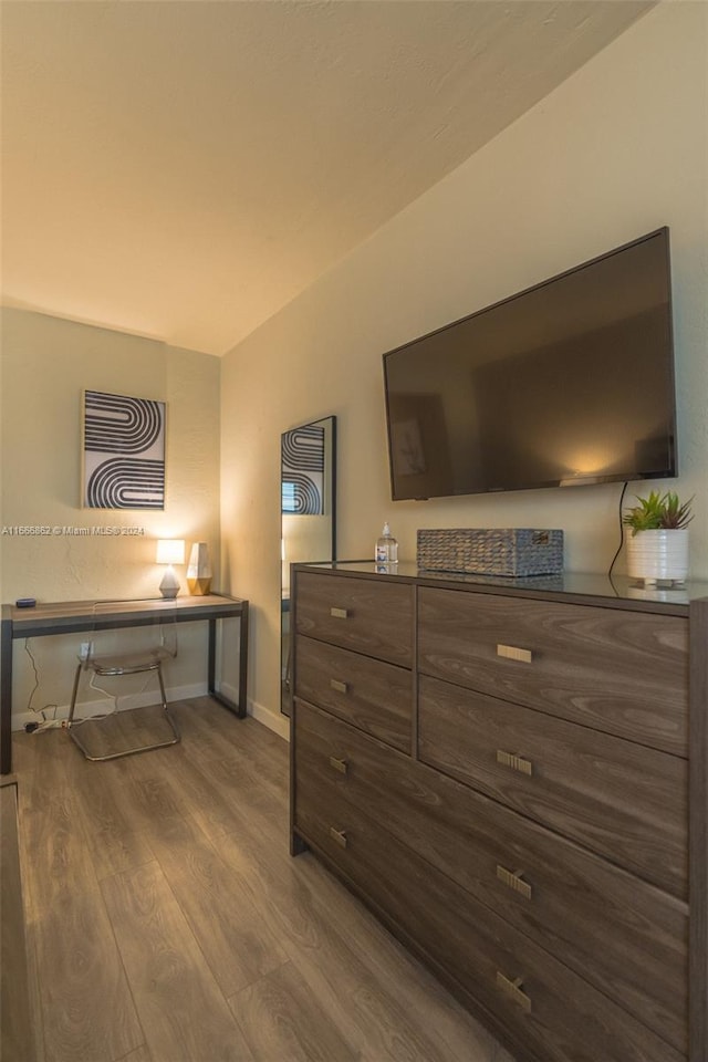 bedroom with hardwood / wood-style flooring and built in desk